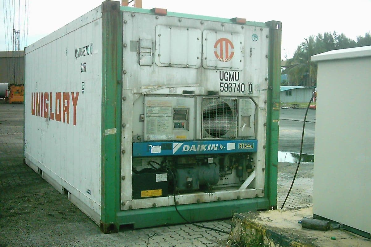 A refrigerated container plugged in at a port, its cooling unit visible